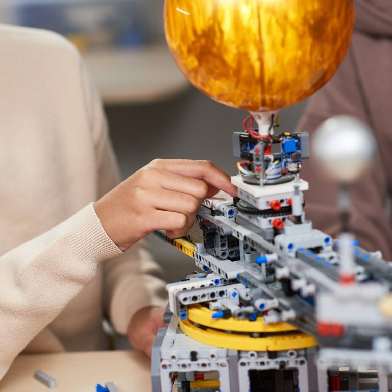 (c) Unsplash Jemand baut ein Modell eines Sonnensystems aus Lego mit einer Sonne und Planeten.